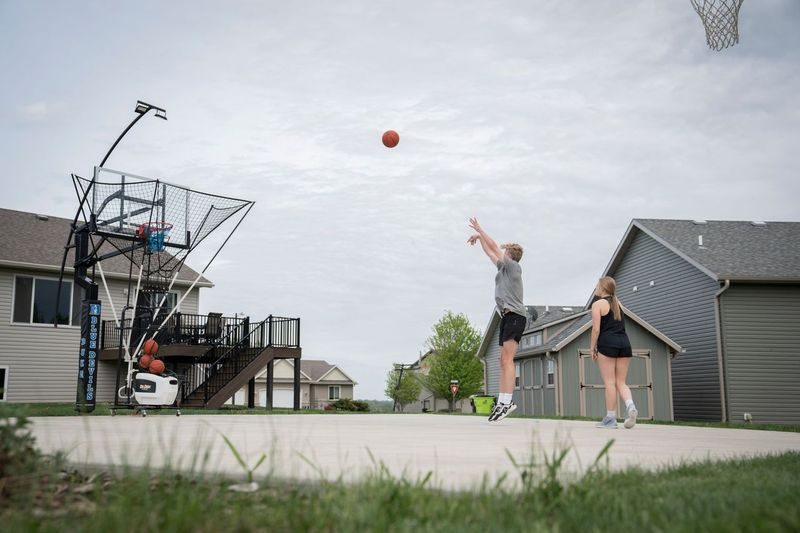 Player shooting outdoors with a Dr. Dish machine returning the ball